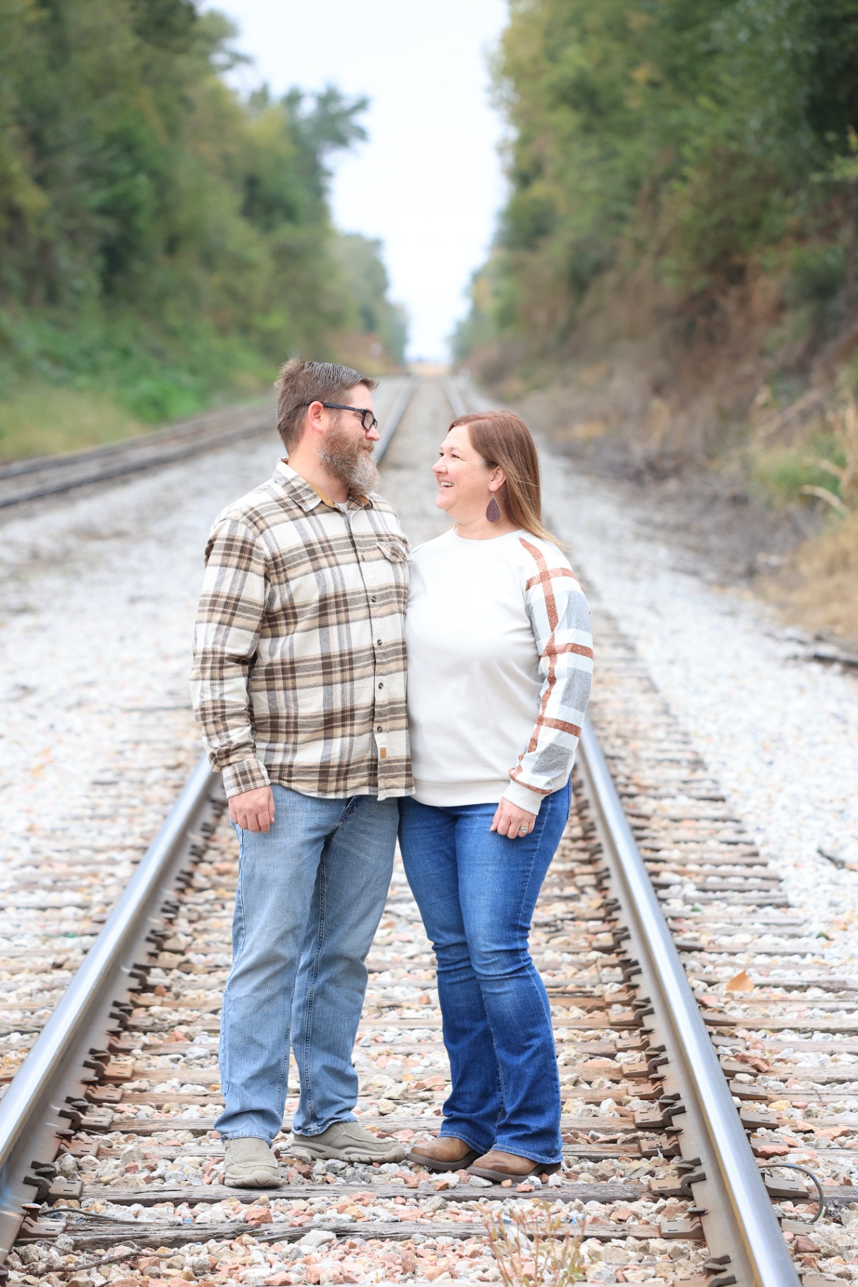 Couple laughing on train tracks